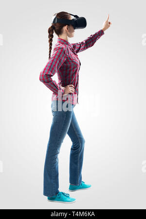 Woman interacts with virtual reality using a vr headset. Concept of ...