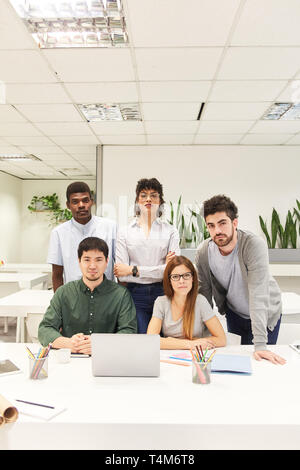 Multicultural business start-up team in coworking office at laptop computer Stock Photo