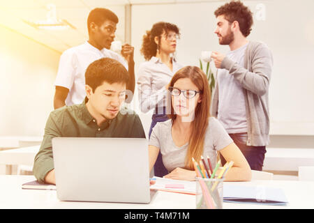 Software developers work as a team with laptop computers in the business office Stock Photo