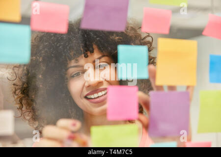 Young African business woman is making brainstorm with colorful sticky notes in the office Stock Photo
