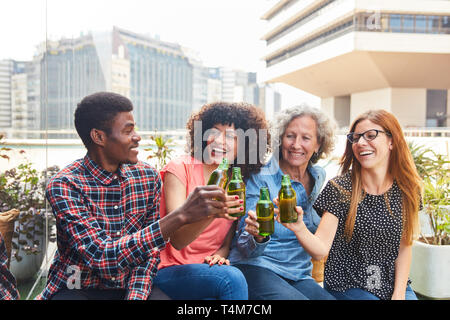 Happy colleagues team drinking beer together in front of the office after work Stock Photo