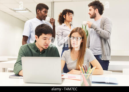 Two colleagues as software developers at laptop computer in coworking office Stock Photo