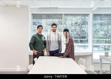 Three young men as students and friends in seminar room or coworking office Stock Photo