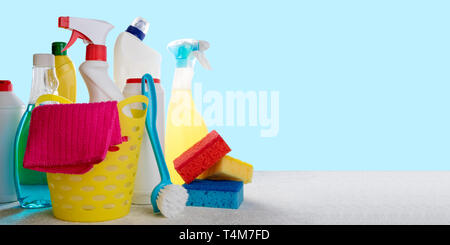 Basket with cleaning products on blue background. Cleaning with supplies, cleaning service concept. Copy space Stock Photo