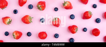 Strawberry and blueberry on pink background. Berries pattern, flat lay. Summer berry banner. Creative food concept Stock Photo