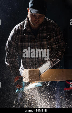 Man using modern electric circular saw for ctting wood  in the workshop Stock Photo