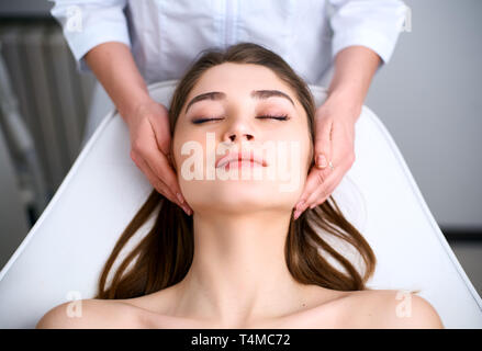 Beautician cleaning woman's face. Spa skincare treatment. Cosmetologist with patient on medical chair. Healthy skin cosmetology. Masseur making relax Stock Photo