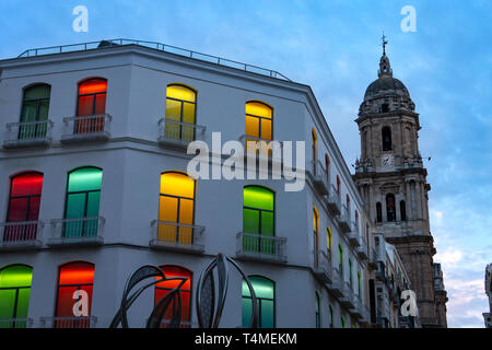 Colorful lights in windows of an building in Malaga Spain with Cathedral Stock Photo