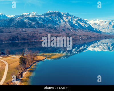 Mountain lake in early spring with snowy peaks. Beautiful nature. Reflection on the lake Stock Photo
