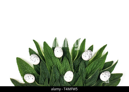 Easter eggs with green leaves. Flat lay. Stock Photo
