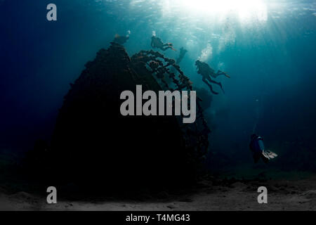 Underwater photographer of divers ascending over the shipwreck of Abu Ghoson, Egypt. Stock Photo