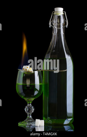 Absinthe bottle and glass with lump sugar burning Stock Photo