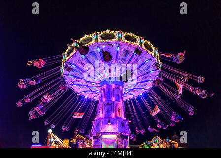 Colorful illuminated fairground attraction - chain carousel Stock Photo