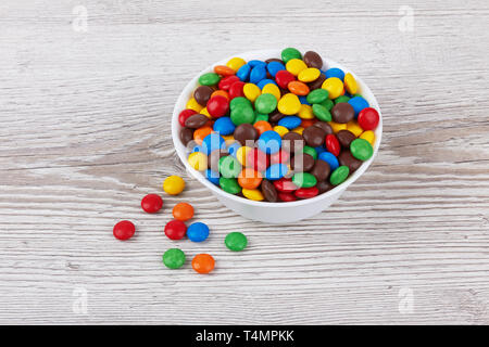 colorful chocolate buttons on wooden background Stock Photo