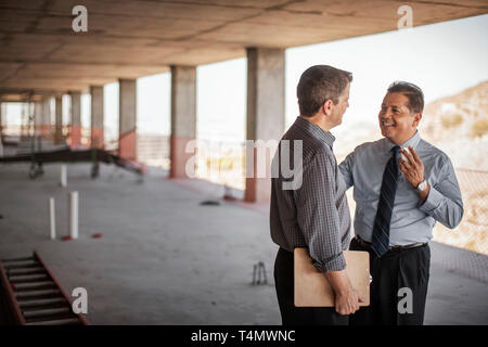 Two executives talking on construction site. Stock Photo