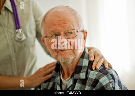 Elderly patient being comforted by a female doctor. Stock Photo