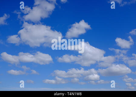 white puffy clouds on bright blue sky background, norfolk, england Stock Photo