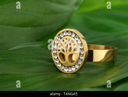 Jewelry ring with diamonds, shape of tree, on leafs background Stock Photo