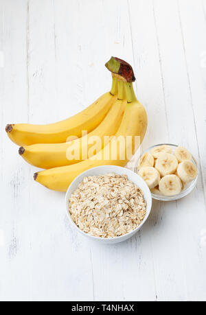 Bowl of oat flakes with sliced banana on wooden table Stock Photo