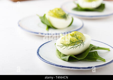 Deviled eggs with avocado and spinach on festive Easter table, close up, selective focus Stock Photo