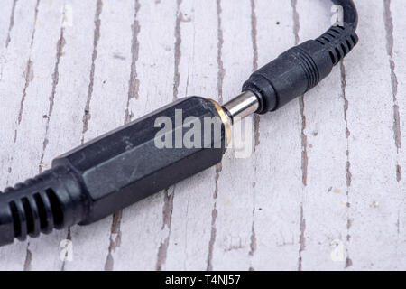 chinch connector plug in black for headphones on white old wood Stock Photo