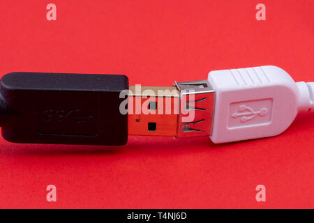 data cable extension plug white and black cable together on red background Stock Photo