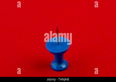 blue pin on red background Stock Photo