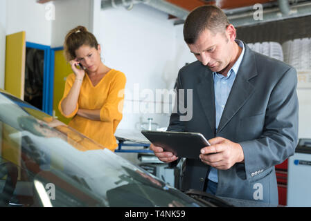 male insurance agent examining car after accident Stock Photo