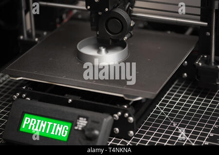 3D model being printed on a 3D printer with a metal heatbed and green LCD. Stock Photo