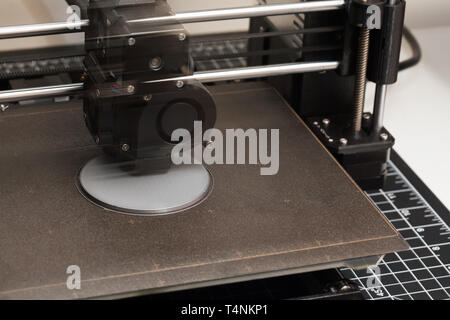 A closeup of a 3D printer in the process of printing a prototype design from a digital file while showing the extruder in motion. Stock Photo