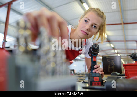 portrait of focused serious female worker holding a drill Stock Photo
