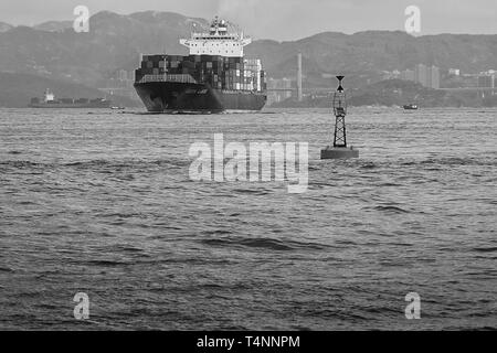 Black And White Photo Of The Container Ship KOTA LUKIS, Leaving The Kwai Tsing Container Terminals, Hong Kong & Heading To The East Lamma Channel Stock Photo