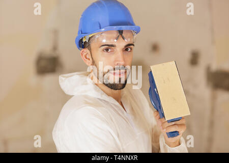 carpenter using sander machine sanding on pine wood surface Stock Photo