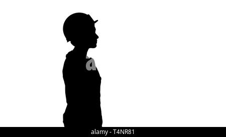 Medium shot. Side view. Silhouette Construction worker lady walking emotionless. Professional shot in 4K resolution. 006. You can use it e.g. in your  Stock Photo
