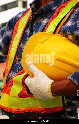 the worker in safety form holding helmet in hand get ready in construction site Stock Photo