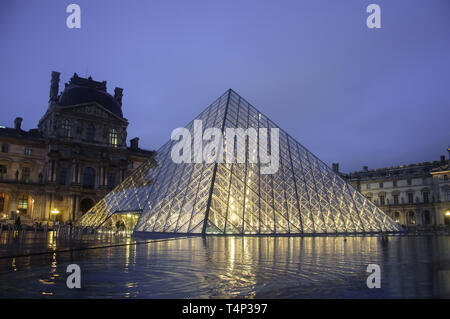 Louvre museum at twilight in winter. Louvre museum is one of the world's largest museums with more than 8 million visitors each year. Stock Photo