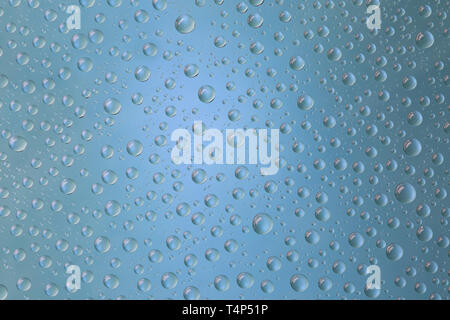 Beautiful water droplets of regular shape on frosted glass with blue light Stock Photo