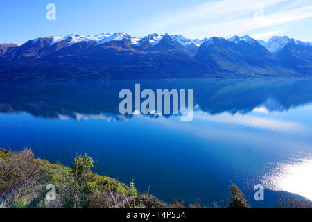 Beautiful crystal clear water lake and mountain reflection blue sky landscape wallpaper peaceful lifestyle in Glenorchy New Zealand South Island lake Stock Photo