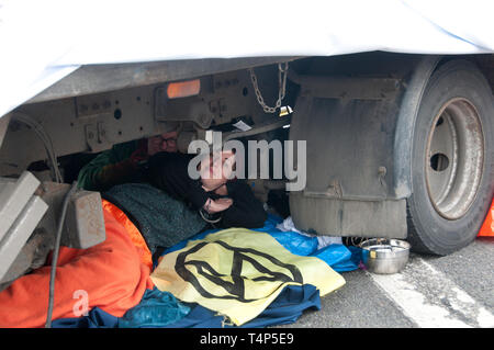 Extinction Rebellion protest, London. April16th 2019. Waterloo Bridge. A protester is locked on to a truck base to prevent arrest and removal. Stock Photo