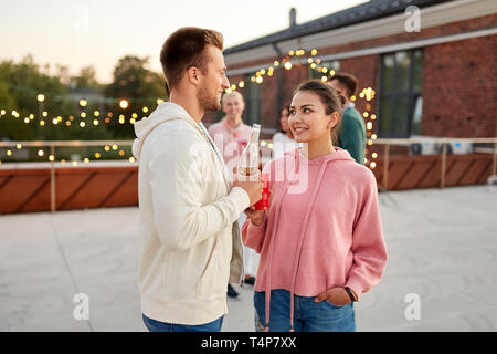 leisure, celebration and people concept - happy friends with non alcoholic drinks at rooftop party in evening Stock Photo