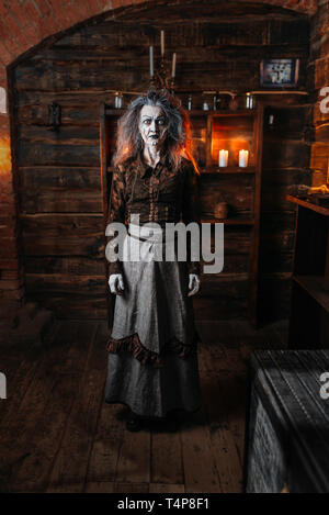 Scary witch stands in her lair, spiritual seance. Female foreteller calls the spirits, terrible fortune teller Stock Photo