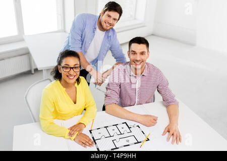 business, architecture and people concept - creative team of architects or interior designers with blueprint working at office Stock Photo