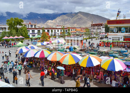 Pilgrims of Tibetan Buddhism, monks, locals, and tourists walking around Barkor, a popular devotional route around Jokhang Temple in Lhasa, Tibet Stock Photo