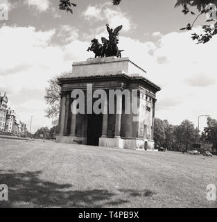 1960s, historical, View Wellington Arch, Hyde Park Corner, London, from this era. A bronze quadriga ( ancient four-horse chariot) has surmounted it since 1912. Up until 1992, it housed the smallest poice station in London. Stock Photo