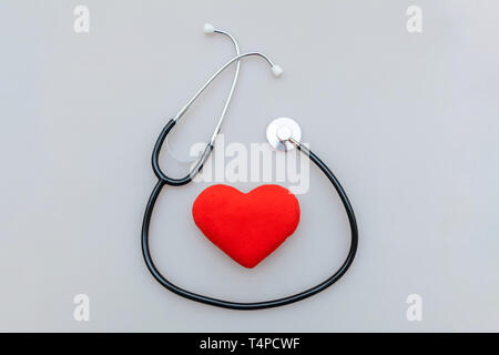 Simply minimal design with medicine equipment stethoscope or phonendoscope and red heart isolated on white background. Instrument device for doctor. H Stock Photo