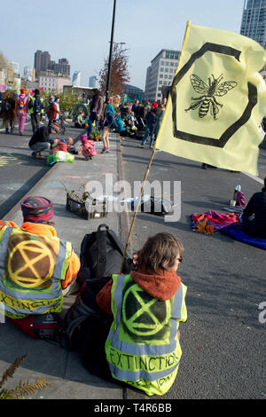 London April 15th 2019. Extinction Rebellion protest to demand action on climate change. Waterloo Bridge; protesters sit down with a bee flag. Stock Photo