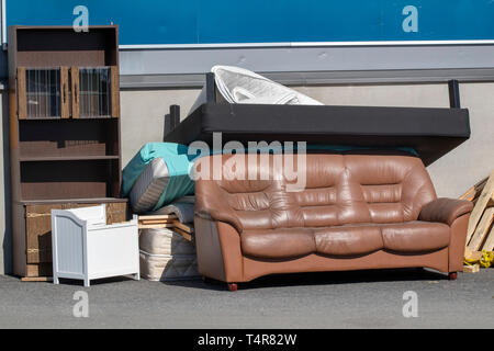 old furniture outdoors on a building wall waiting to be carried away Stock Photo
