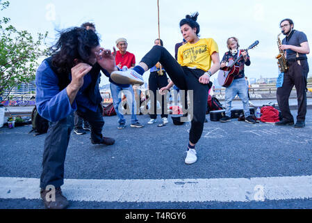 London, UK. 18th Apr, 2019. Capoeira dancers perform as the sun starts to set during 'London: International Rebellion', on day four of a protest organised by Extinction Rebellion. Protesters are demanding that governments take action against climate change. Marble Arch, Oxford Circus, Piccadilly Circus, Waterloo Bridge and Parliament Square have been blocked by activists in the last three days. Police have issued a section 14 order requiring protesters to convene at Marble Arch only so that the protest can continue. Credit: Stephen Chung/Alamy Live News Stock Photo