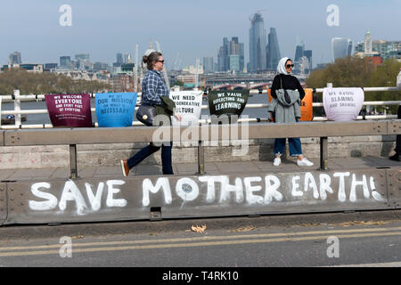 Save mother earth graffiti on Waterloo Bridge made during the Extinction Rebellion Strike in London.  Environmental activists from Extinction Rebellion movement hold for fourth consecutive day Waterloo Bridge in London. Activists has been parked a lorry on the bridge blocking the street causing disruptions. Police have been arresting protesters that refuse to head to Marble Arch. Extinction Rebellion demands from the government direct actions on the climate, reduce carbon emissions to zero by 2025 and a peoples assembly. Stock Photo