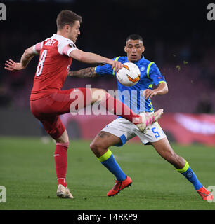 Naples, Italy. 18th Apr, 2019. Arsenal's Aaron Ramsey (L) vies with Napoli's Allan during the UEFA Europa League quarterfinal second leg soccer match between Napoli and Arsenal in Napoli, Italy, April 18, 2019. Napoli lost 0-1. Credit: Alberto Lingria/Xinhua/Alamy Live News Stock Photo